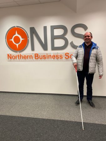 Dr. Carsten Dethlefs vor dem Logo der NBS, Foto: NBS